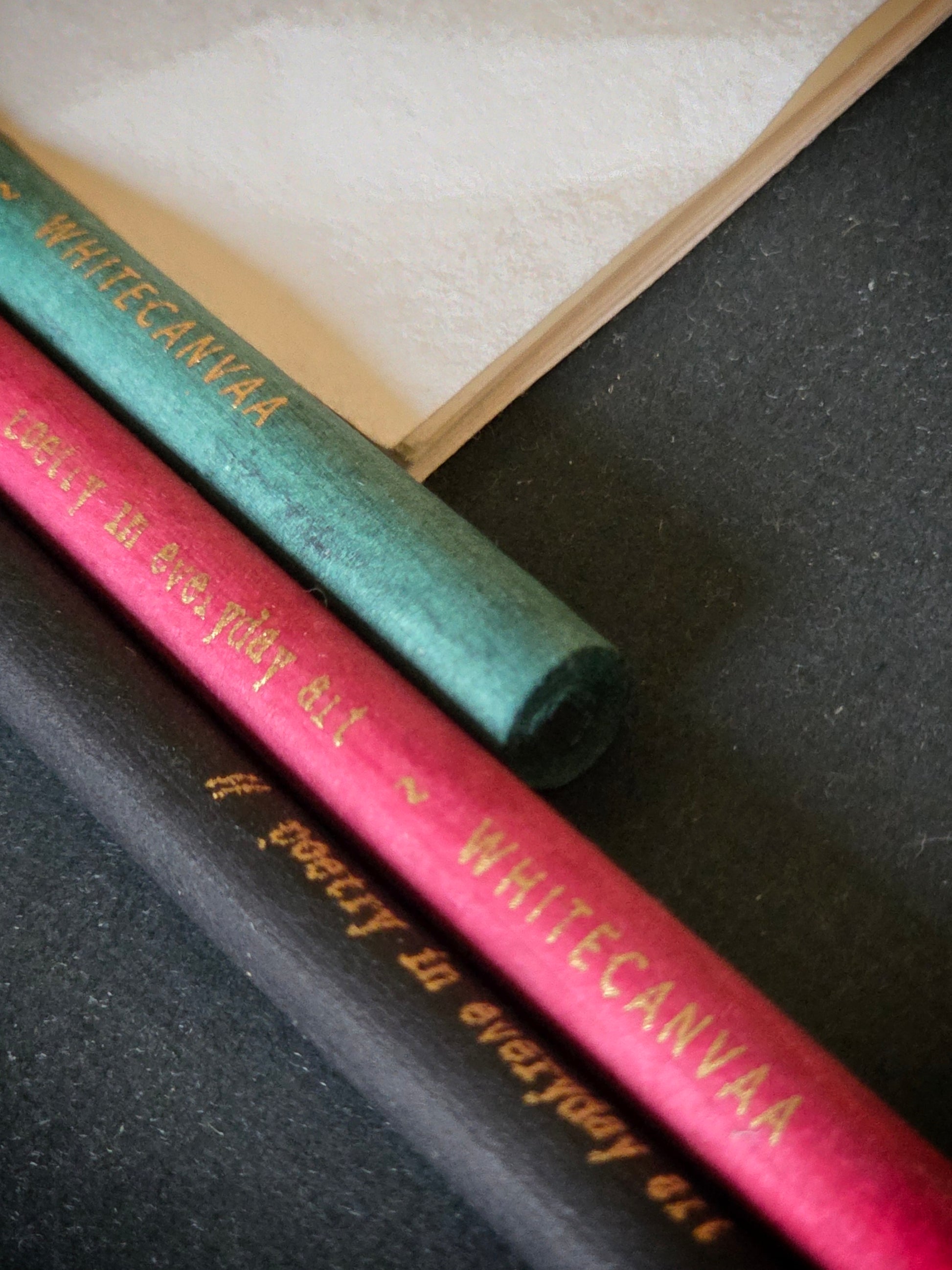 Close up picture of newspaper eco friendly pencils with gold print. White Canvaa 