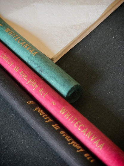 Close up picture of newspaper eco friendly pencils with gold print. White Canvaa 