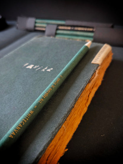 Green vintage sustainable journal with raw deckled edges and a green royal vintage pencil with gold print on it by White Canvaa.